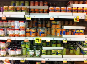 Canned corn, peas and mixed vegetables on supermarket shelves