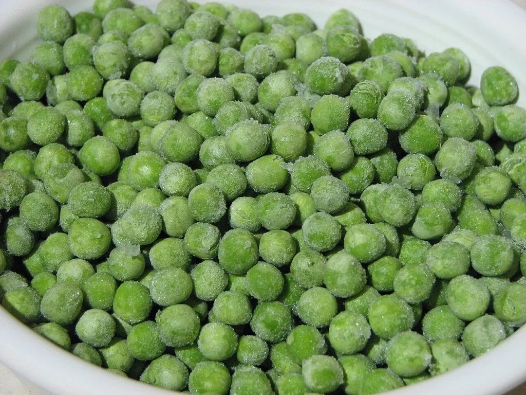 Frozen green peas with visible frost