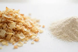 Dehydrated onion flakes vs onion powder on white surface
