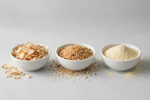 Dehydrated onion flakes, granules and powder in three white bowls