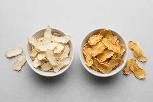Air-dried ginger slices and dehydrated ginger slices in two bowls